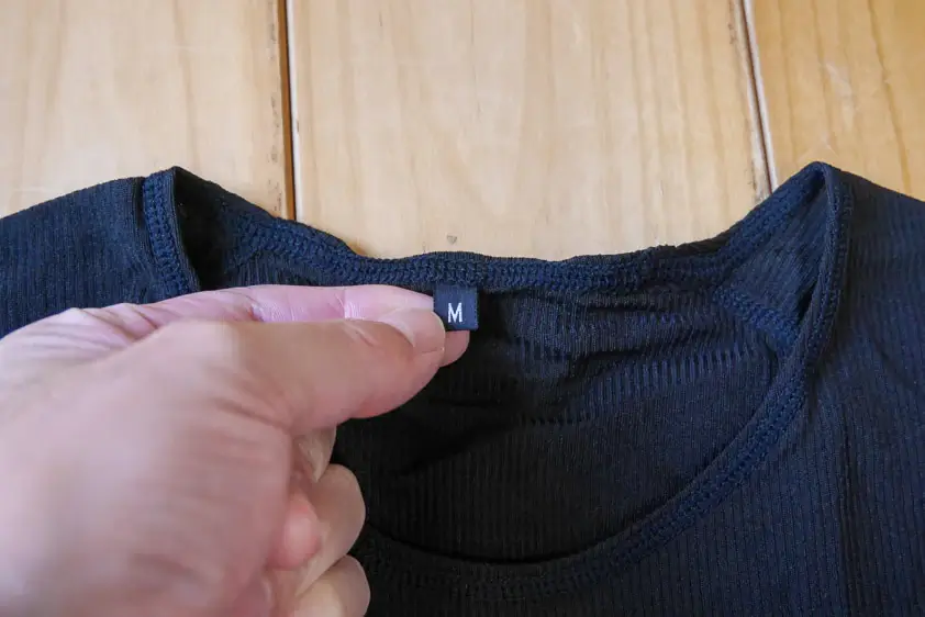 オンヨネ・ブレステックPPショートスリーブの首後ろのサイズタグを持ったところ