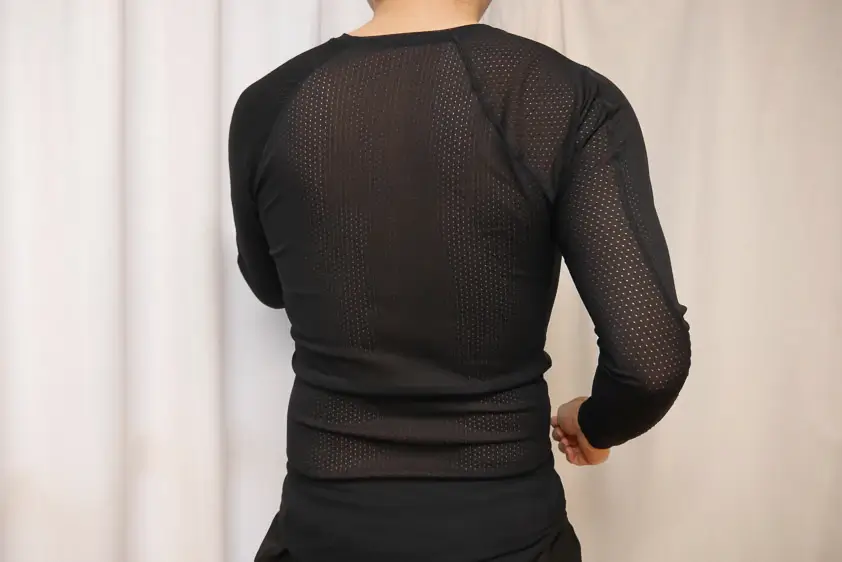 ファイントラックのドライレイヤーベーシック・ロングスリーブを着用して腕振りをしているところ 後ろ